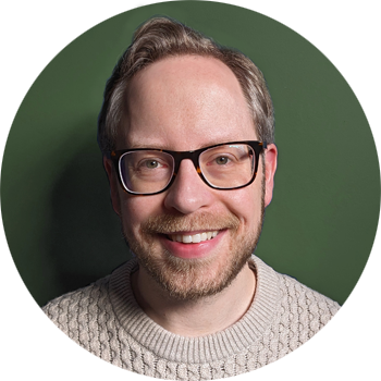 A photo of Chris Baraniuk, the journalist, smiling directly at the camera. He is pictured against a dark green background.